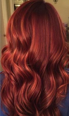 the back of a woman's head with red hair and long wavy curls in it