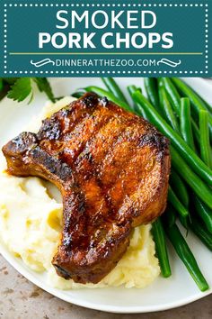 some meat and mashed potatoes on a white plate with green beans next to it