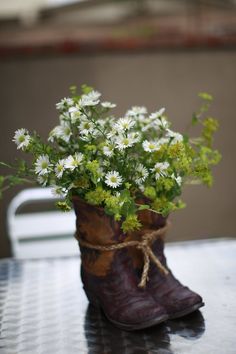 a boot with flowers in it sitting on a table