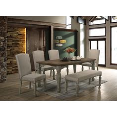 a dining room table with white chairs and a chalkboard on the wall behind it