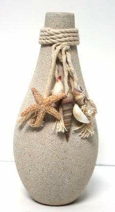 a ceramic vase with shells and starfishs on the bottom, sitting on a white surface