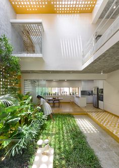 the interior of a modern house with grass and plants on the floor, stairs to the second floor