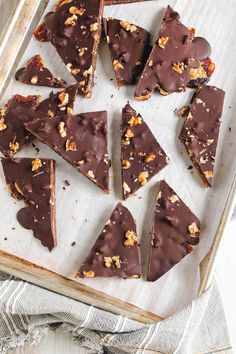 there are many pieces of chocolate with nuts on top in the baking pan, ready to be eaten