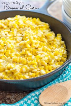 a skillet filled with corn on top of a table