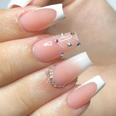 a woman's hand with some white and pink nail polishes on her nails