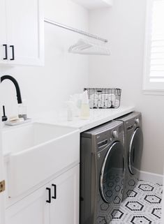 a washer and dryer in a small room next to a sink with black faucet