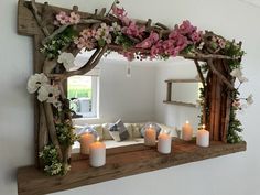 a mirror with flowers and candles in front of it