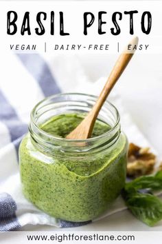 basil pesto in a glass jar with a wooden spoon on the side and text overlay that reads basil pesto vegan dairy - free easy