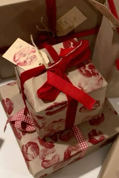 two wrapped presents with red ribbon on them