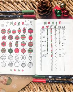 an open notebook with christmas ornaments and holiday stickers on it next to some pencils