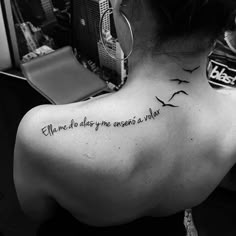 the back of a woman's neck with birds on it