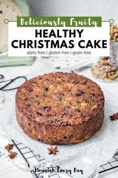 a cake sitting on top of a white plate next to an alarm clock and christmas decorations