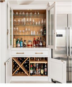 an open cabinet filled with bottles and glasses