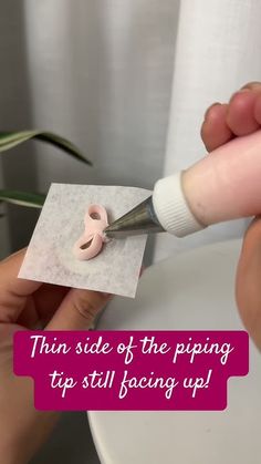 someone cutting paper with a pair of scissors on top of it and the words, thin side of the piping tip still facing up