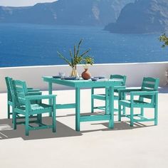 a table and chairs on a patio overlooking the ocean