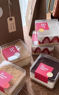 four different desserts in plastic containers on a wooden table with tags attached to them