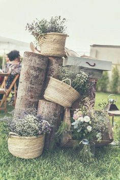 several baskets are stacked on top of each other in front of people sitting at an outdoor table