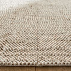 a close up view of a rug on the floor with wood floors and white carpet