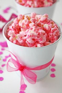 two white bowls filled with pink and yellow popcorn