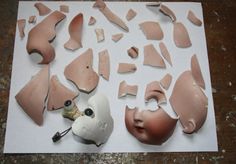 several pieces of broken clay sitting on top of a white piece of paper that has been cut out