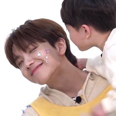 a young boy is kissing the face of an older woman with her nose painted white