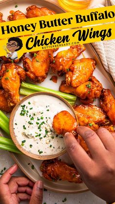 a person dipping sauce on top of chicken wings with celery and green beans