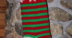 a pair of red and green socks hanging from a stone wall