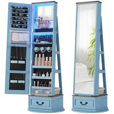 a blue jewelry cabinet sitting next to a mirror on top of a wooden stand with drawers