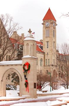 a clock tower with a wreath on it in the snow