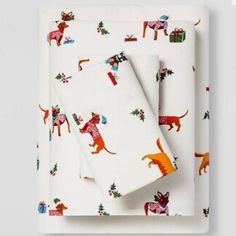 a white plate topped with two napkins covered in christmas animals and presents on them