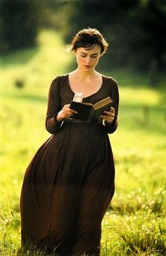 a woman in a brown dress reading a book