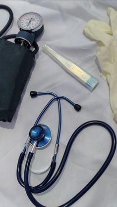 a doctor's stethoscope and other medical supplies on a white sheet