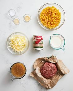 ingredients to make macaroni and cheese are laid out on a white counter top