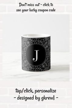 a black and white coffee mug with the letter j on it's bottom corner