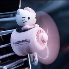 a hello kitty air freshener hanging from the inside of a car's dashboard