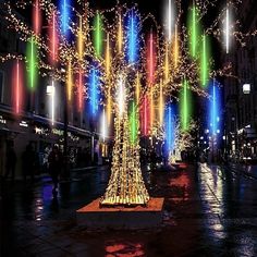 a lighted christmas tree in the middle of a city street