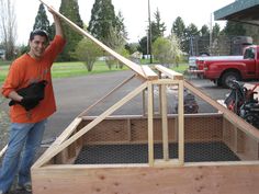 a man standing next to a wooden structure