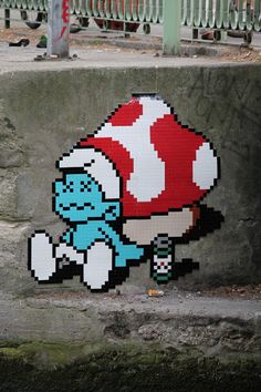 an image of a pixel art on the side of a building with a blue cat holding a mushroom