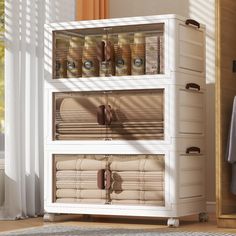 a white cabinet filled with lots of jars and containers on top of each other in front of a window