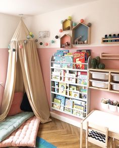 a child's playroom with pink walls and lots of toys on the shelves