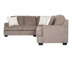 a sectional couch with pillows on it and a white pillow in the back ground, against a white background