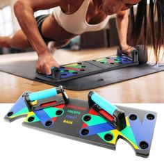 a woman is doing push ups on a mat with two different colored handles and feet