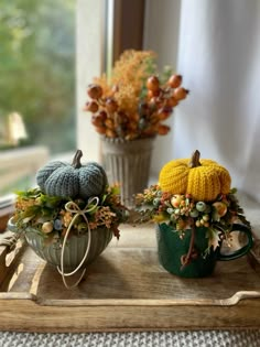 two crocheted pumpkins are sitting on a tray