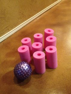 several pink rollers and a purple ball on the floor