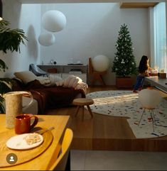 a woman sitting on a couch in a living room next to a table and chair