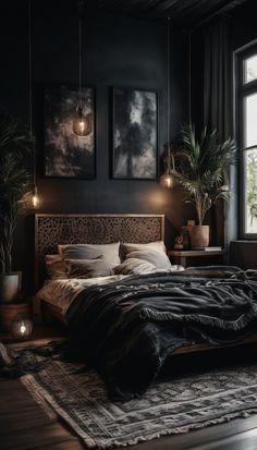 a bedroom with black walls and wooden floors, two paintings on the wall above the bed