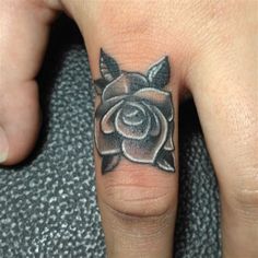 a person with a rose tattoo on their ring finger