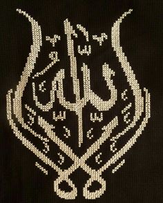 an embroidered black shirt with white writing on the front and bottom, in arabic script