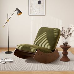 a green chair sitting on top of a rug next to a lamp