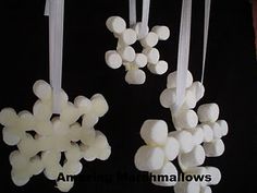 marshmallows hanging from strings on a black background